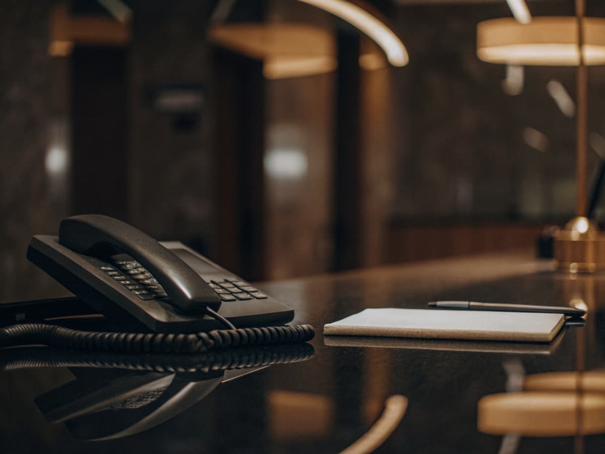 Professional business contact desk with phone and notepad